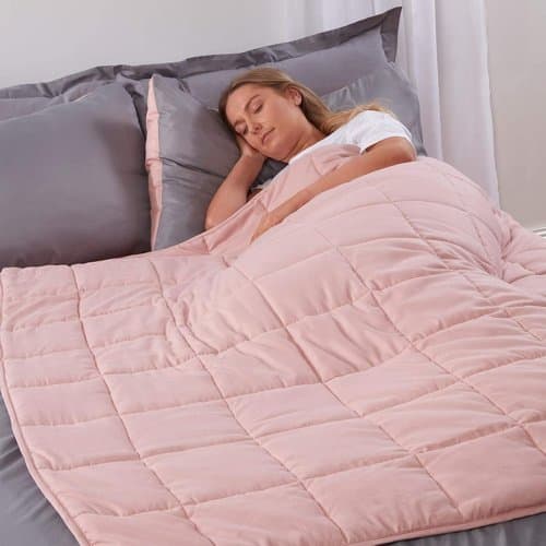 Pink Brentfords weighted blanket with quilted square pockets on a bed