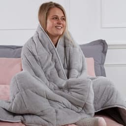 Silver grey Brentfords teddy fleece weighted blanket on a sofa